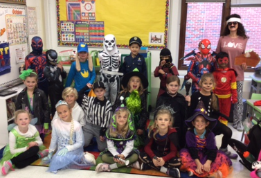 Students dressed up at their Halloween party posing for a class picture.