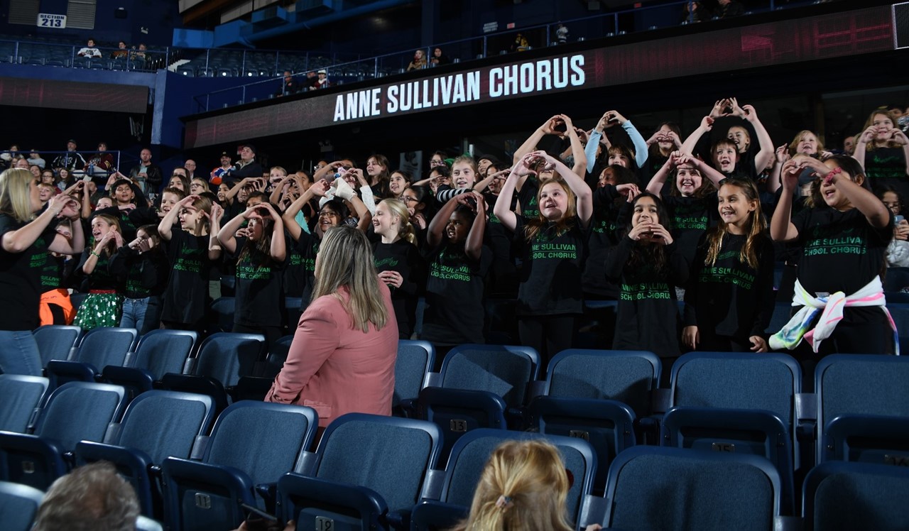 Sullivan Chorus performing the song &#34;Happy&#34; at the Chicago Wolves game