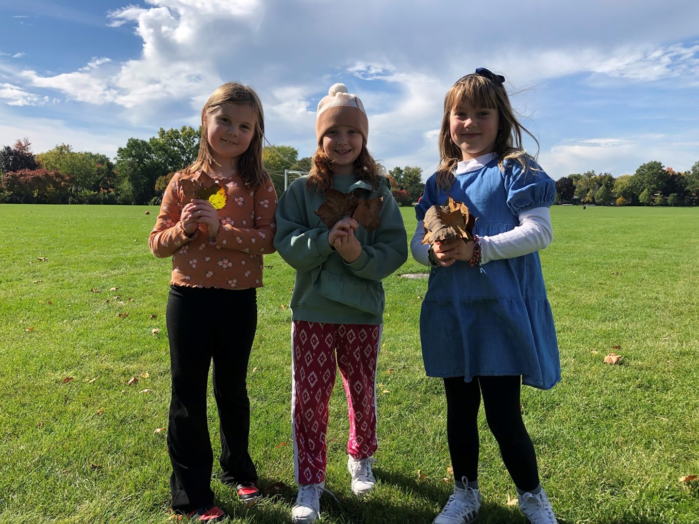 Students at recess holding leaves.
