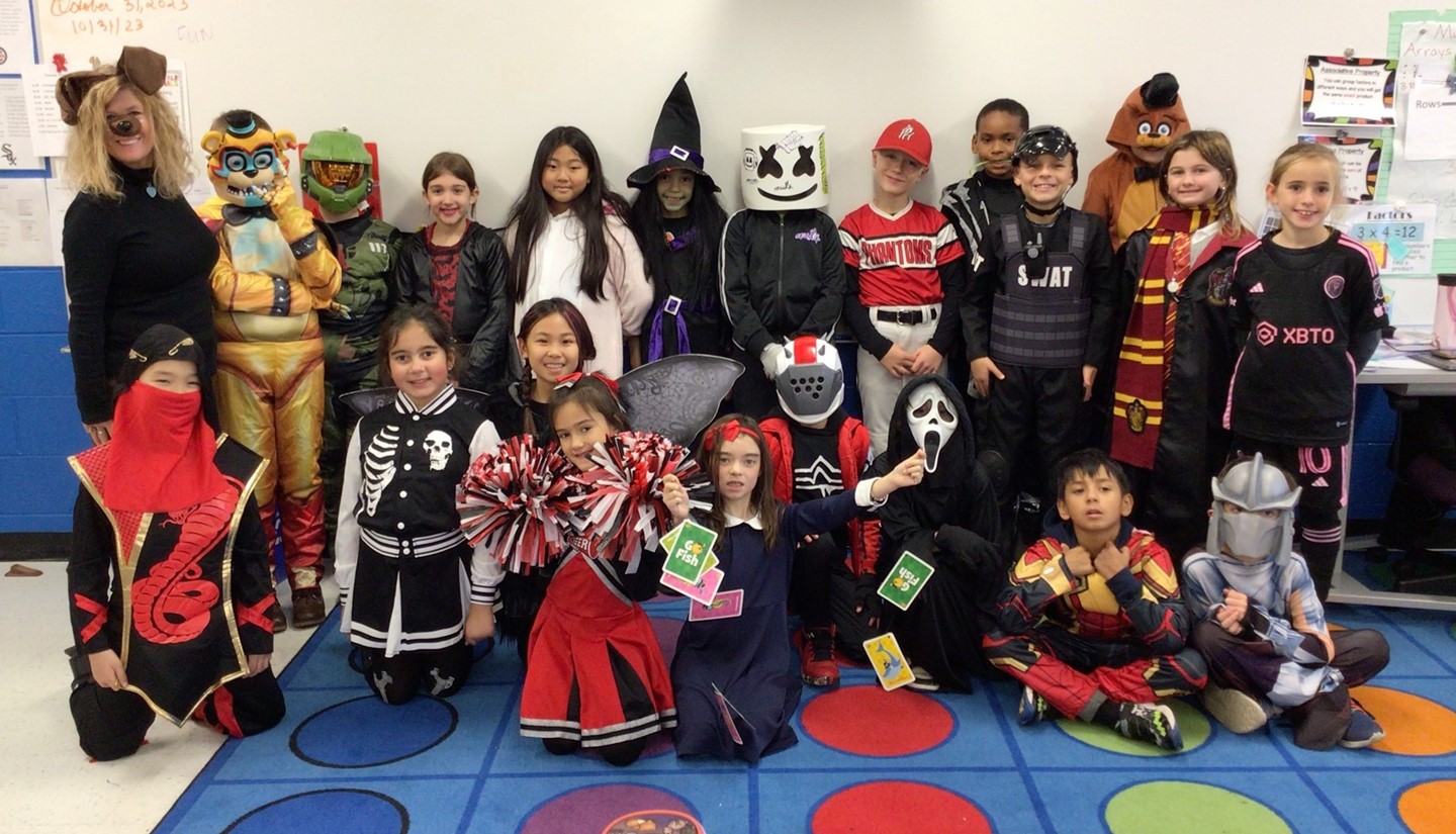 Students in Halloween costumes taking a class picture.
