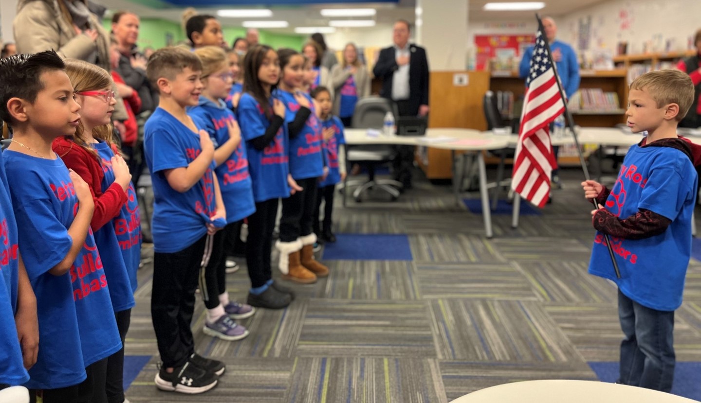 Students at the Board meeting saying the pledge of allegiance.