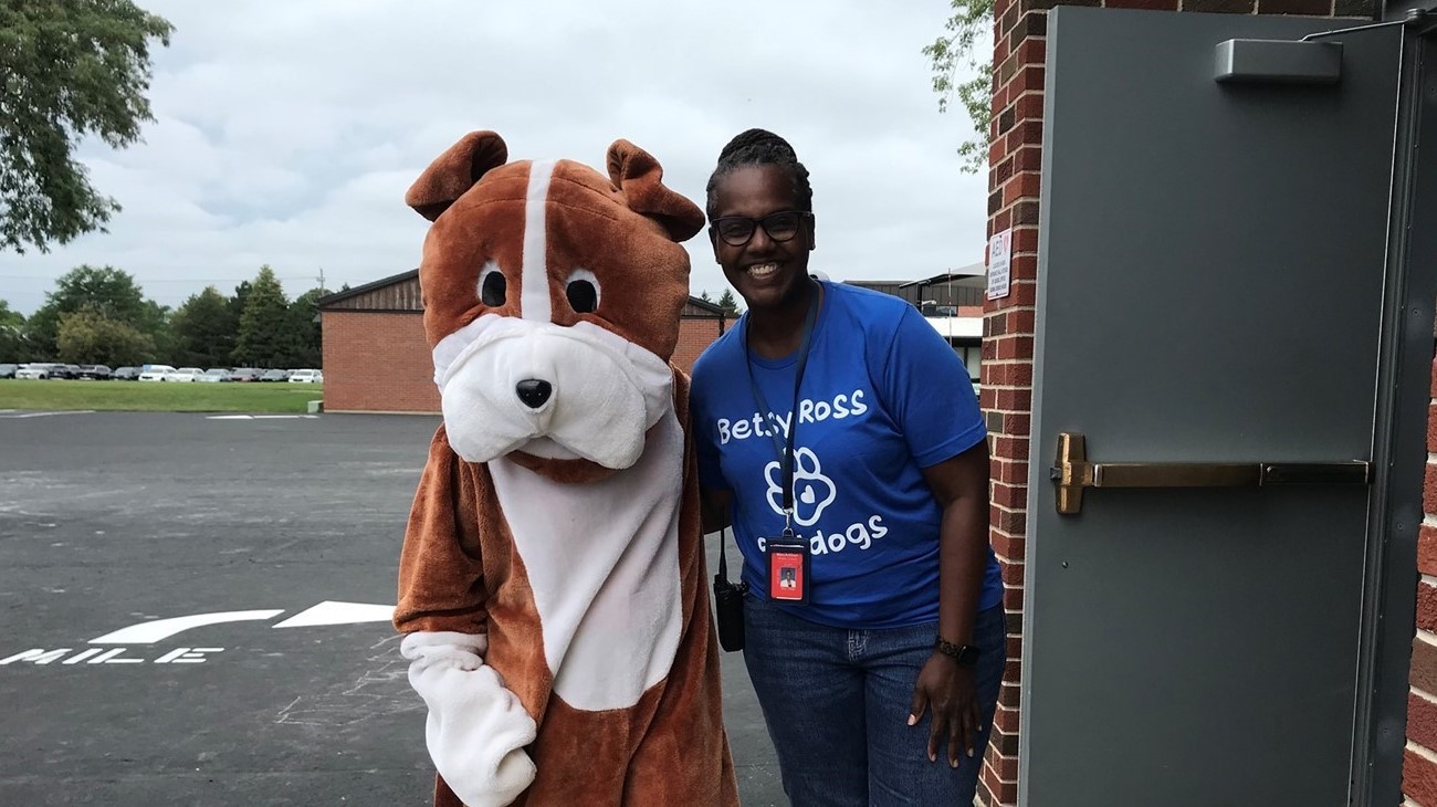 Principal Gage with the bulldog posing for a pic outside.